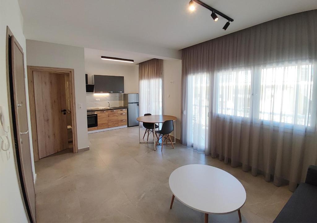 a living room with a table and a kitchen at K78 Studios A1 in Nea Michaniona