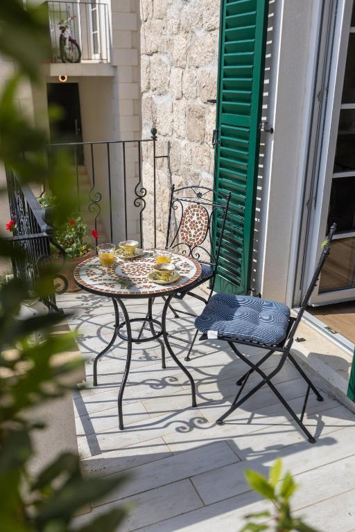 a table and chairs sitting on a patio at NEW - Casa Columba - 4 Star Design Boutique Hotel with Outdoor Pool & Private Garden in Makarska