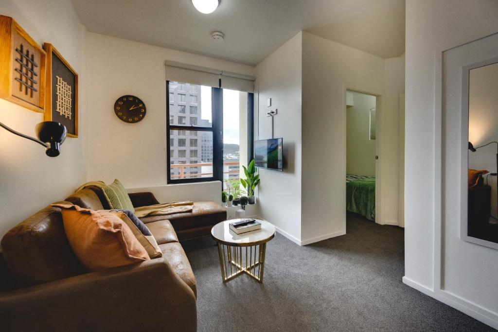 a living room with a couch and a table at Top Floor - Free Parking - Central Location - Quiet - City View in Wellington