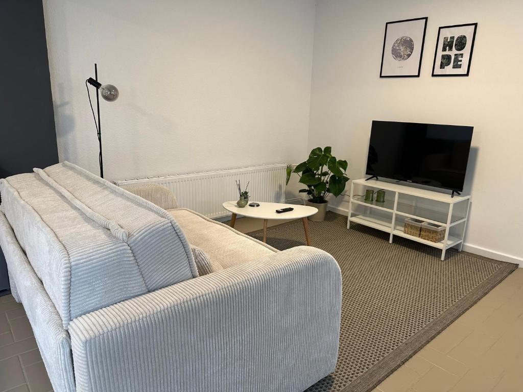 a living room with a couch and a tv at BSD Apartment - Self Check-in & Parkplatz in Bochum