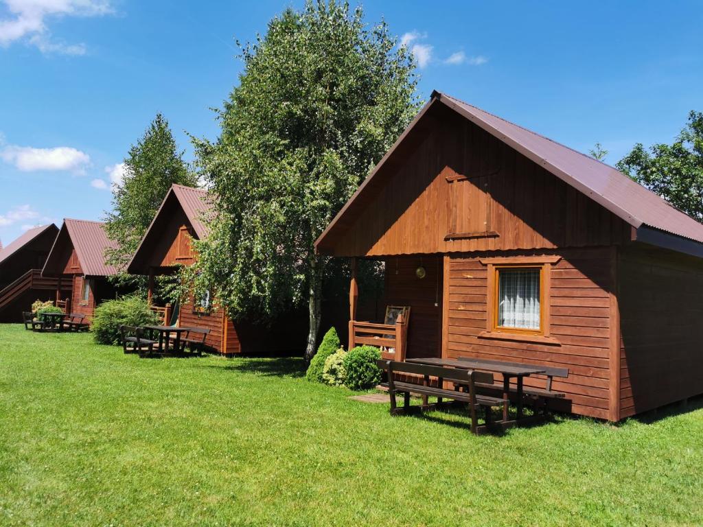 a log cabin with a picnic bench in the grass at Domki Jaśmin 781-012-181 in Polańczyk
