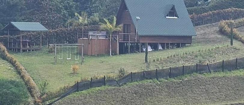 a house in a field with at Cabaña glamping in Rionegro