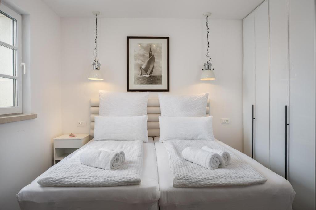 two beds in a bedroom with white walls at NEW - Casa Columba - 4 Star Design Boutique Hotel with Outdoor Pool & Private Garden in Makarska