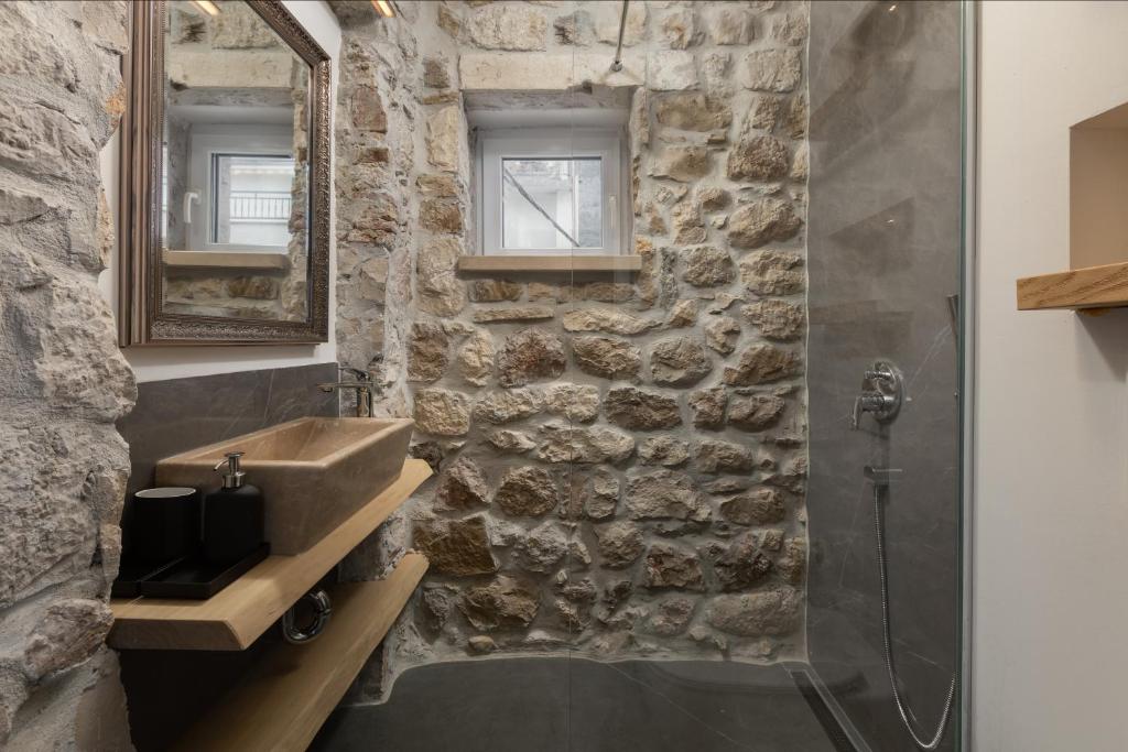 a stone bathroom with a sink and a shower at NEW - Casa Columba - 4 Star Design Boutique Hotel with Outdoor Pool & Private Garden in Makarska
