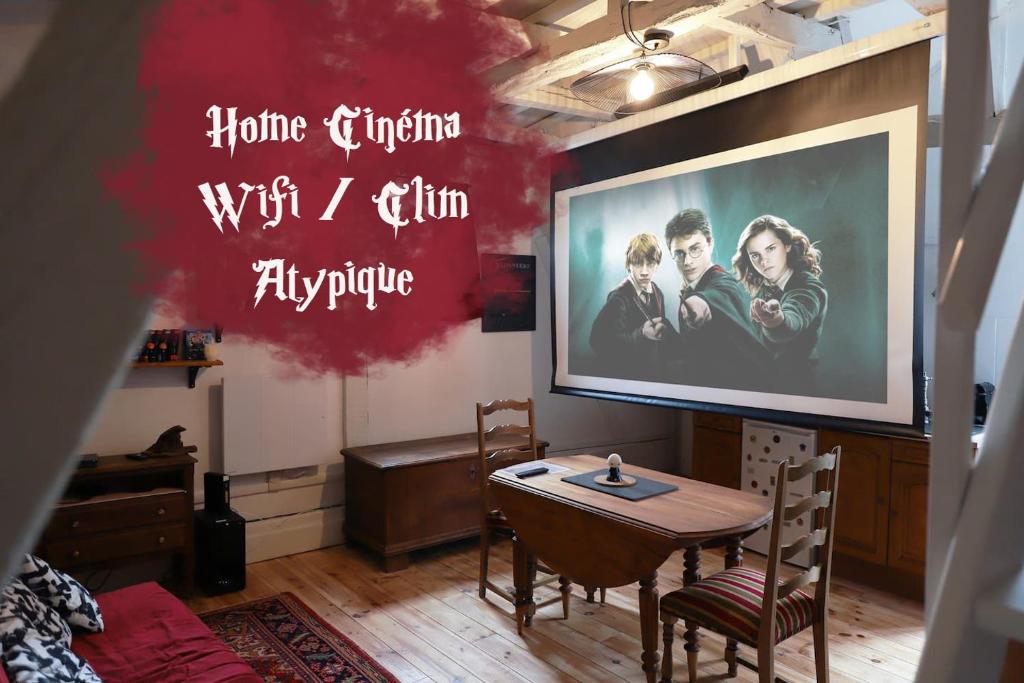 Cette chambre dispose d'une table et d'un grand écran. dans l'établissement La tanière du sorcier, à Saumur