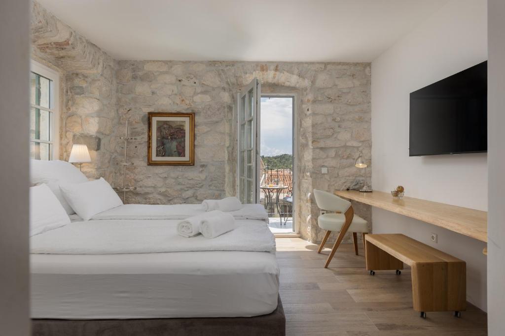 a bedroom with two beds and a desk with a television at NEW - Casa Columba - 4 Star Design Boutique Hotel with Outdoor Pool & Private Garden in Makarska
