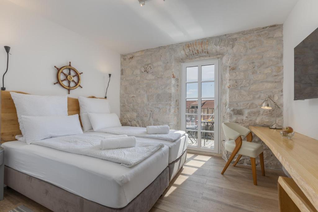 a large bed in a room with a stone wall at NEW - Casa Columba - 4 Star Design Boutique Hotel with Outdoor Pool & Private Garden in Makarska