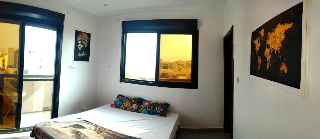 een slaapkamer met een bed en een raam met uitzicht bij Belle petite chambre calme à Ngor, Dakar in Dakar