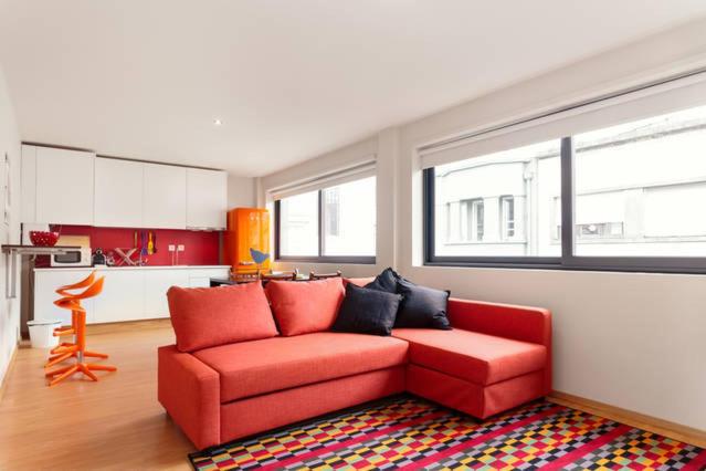 ポルトにあるPicaria Apartmentのリビングルーム(赤いソファ付)、キッチン