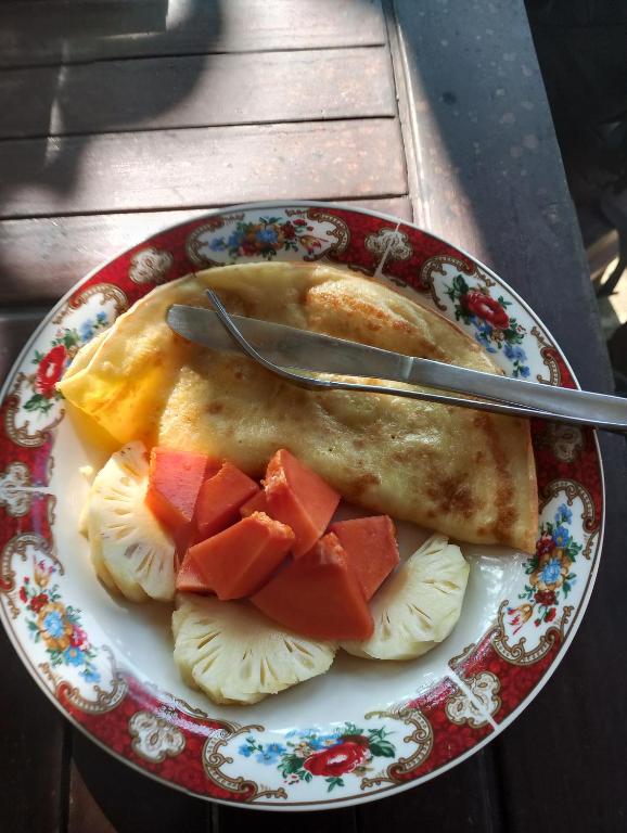ein Teller mit Essen und Obst auf einem Tisch in der Unterkunft Tetebatu Fullmoon in Tetebatu