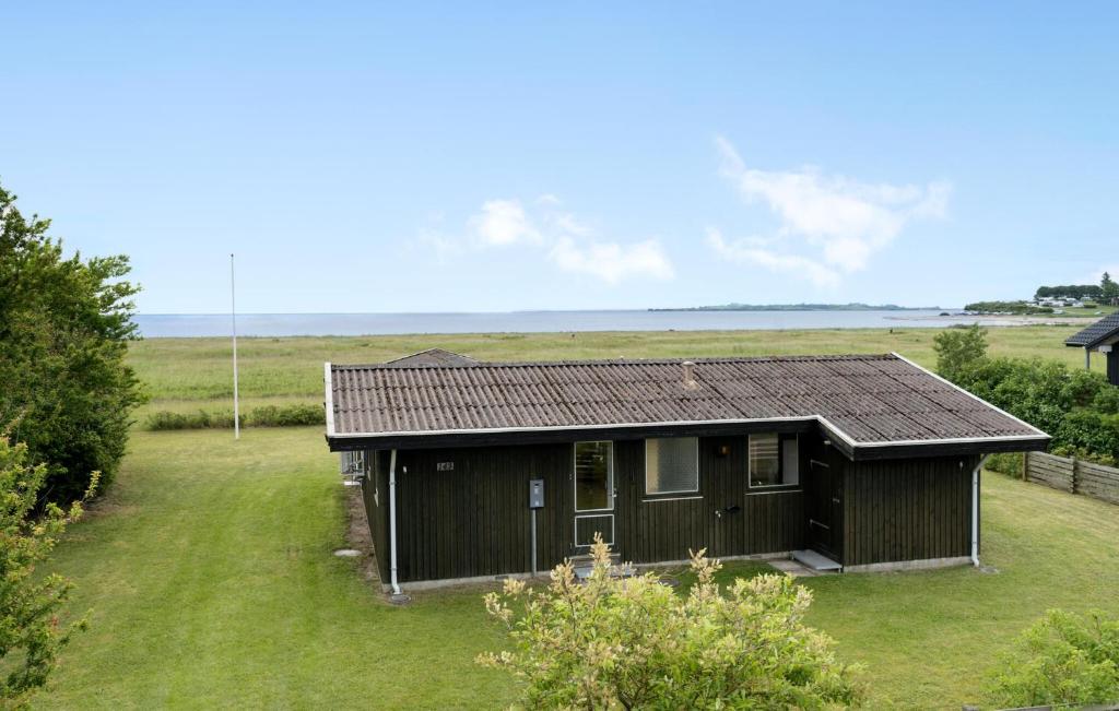 a small black house in the middle of a field at Awesome Home In Haderslev With Wifi in Haderslev