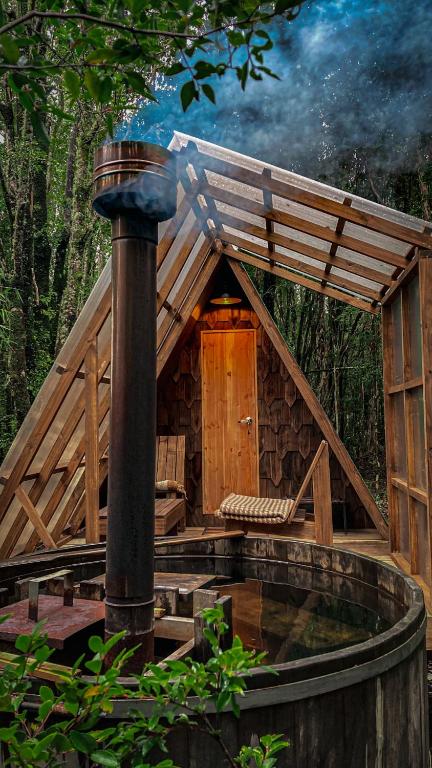 a large wooden cabin with a roof and a porch at Parque Repuleufu Chiloé in Ancud