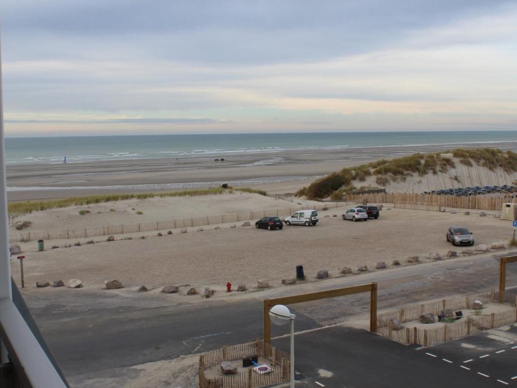 - une vue sur une plage avec des voitures garées dans un parking dans l'établissement Appartement T2 près de la plage, animaux admis - FR-1-482-145, à Fort-Mahon-Plage
