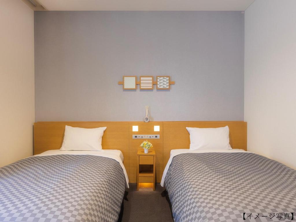 Postel nebo postele na pokoji v ubytování Yokohama Sakuragicho Washington Hotel
