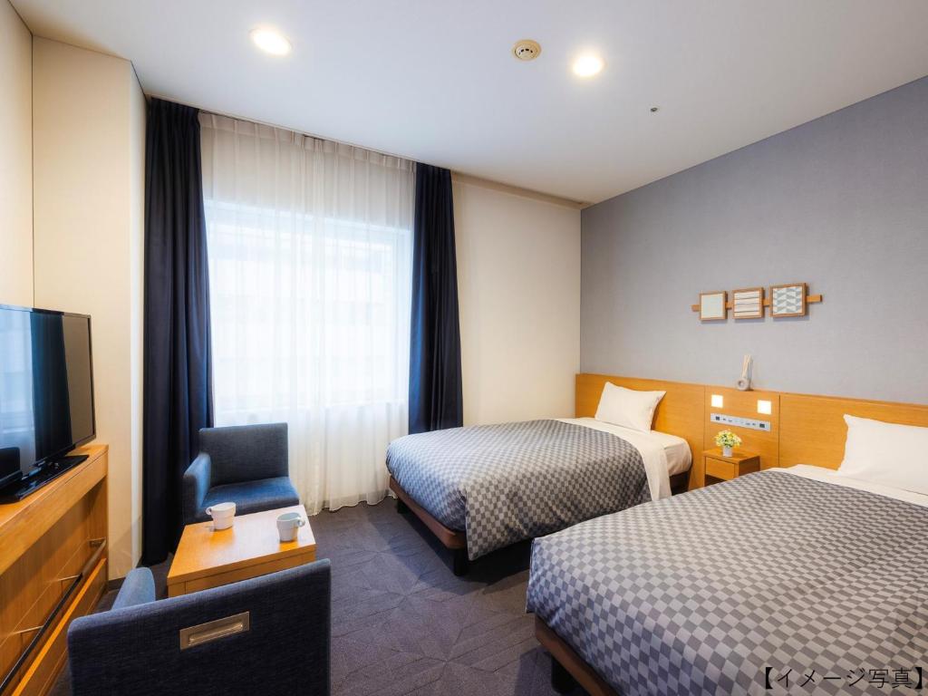 Postel nebo postele na pokoji v ubytování Yokohama Sakuragicho Washington Hotel