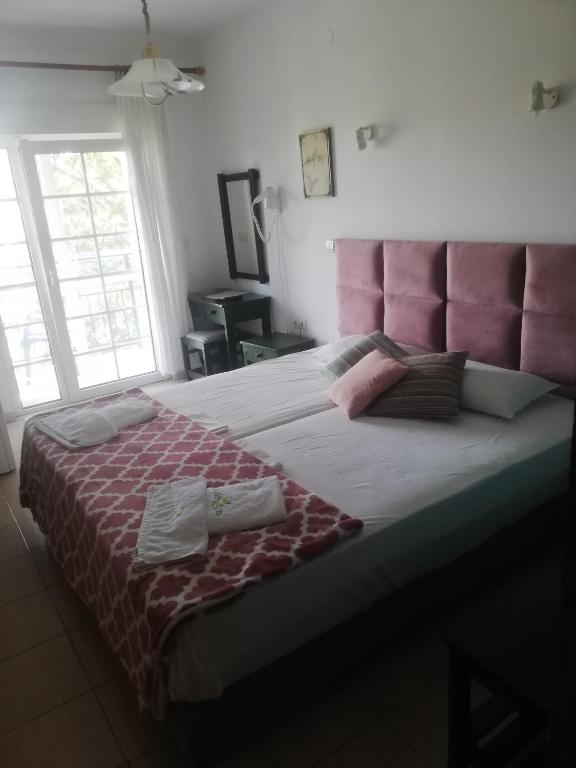 a large bed with a pink headboard in a bedroom at Dimitriadis fresh Edem in Limenas