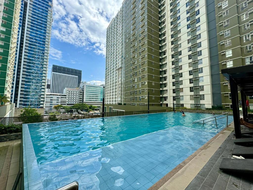 a large swimming pool in a city with tall buildings at Avida Riala Condotel T4-1103 in Cebu City