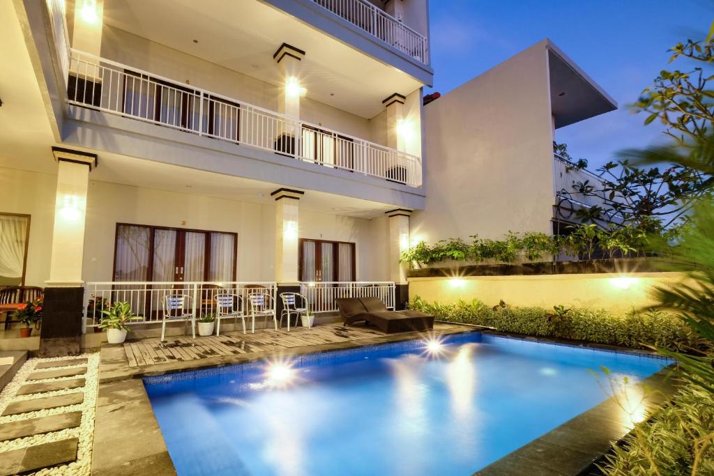 a villa with a swimming pool at night at Puspa Canggu in Canggu
