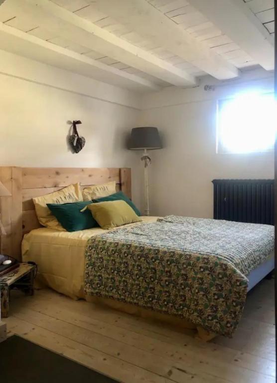 une chambre avec un grand lit avec des oreillers verts dans l'établissement La parenthèse, à Charnay-lès-Mâcon