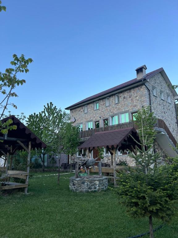 duży kamienny budynek ze stołem piknikowym przed nim w obiekcie Guesthouse Makry w mieście Pukë