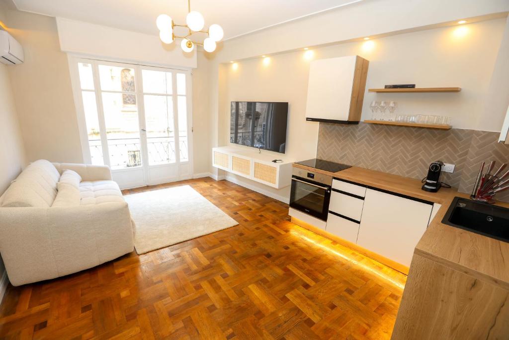 un salon avec un canapé blanc et une cuisine dans l'établissement Nice carré d'or proche Negresco, à Nice