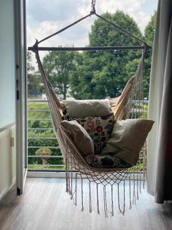 a hammock with pillows in a room with a window at Chrisma Apartments in Düsseldorf