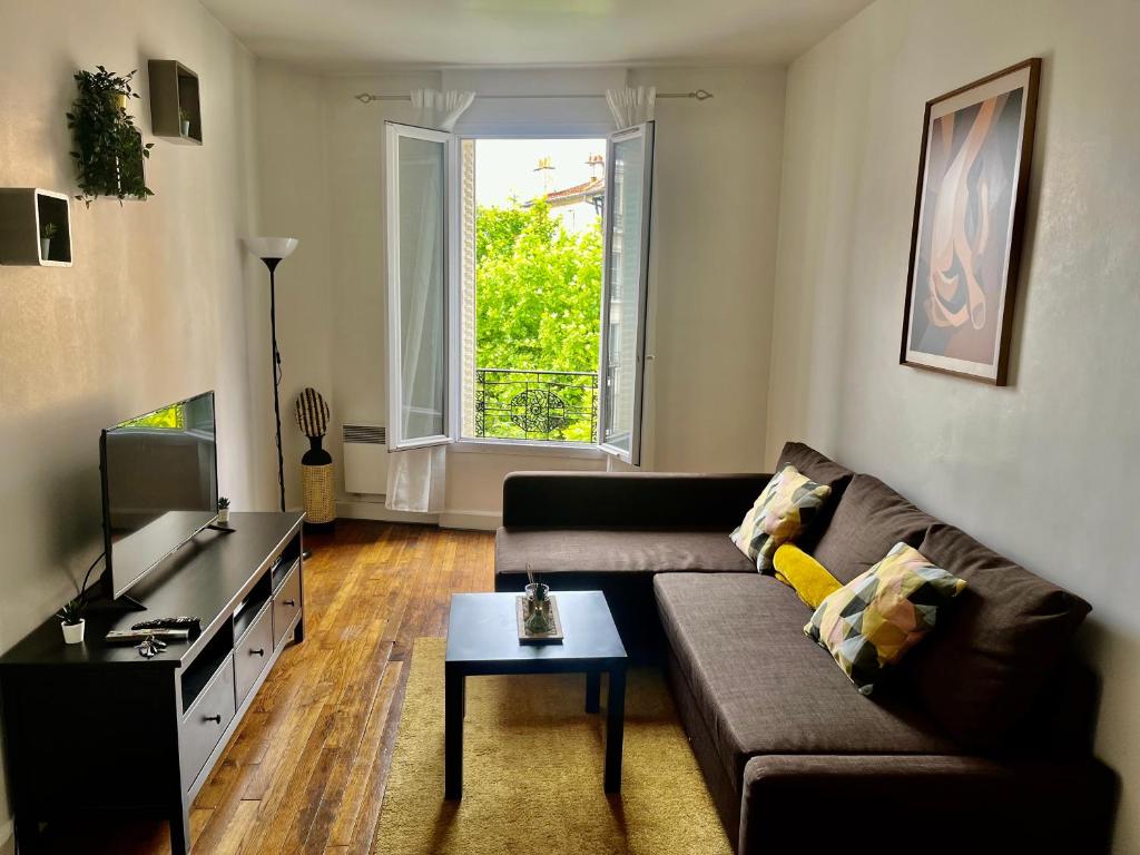 un salon avec un canapé et une télévision dans l'établissement Manaca F2 - Le Raincy Centre Ville-Paris, à Le Raincy