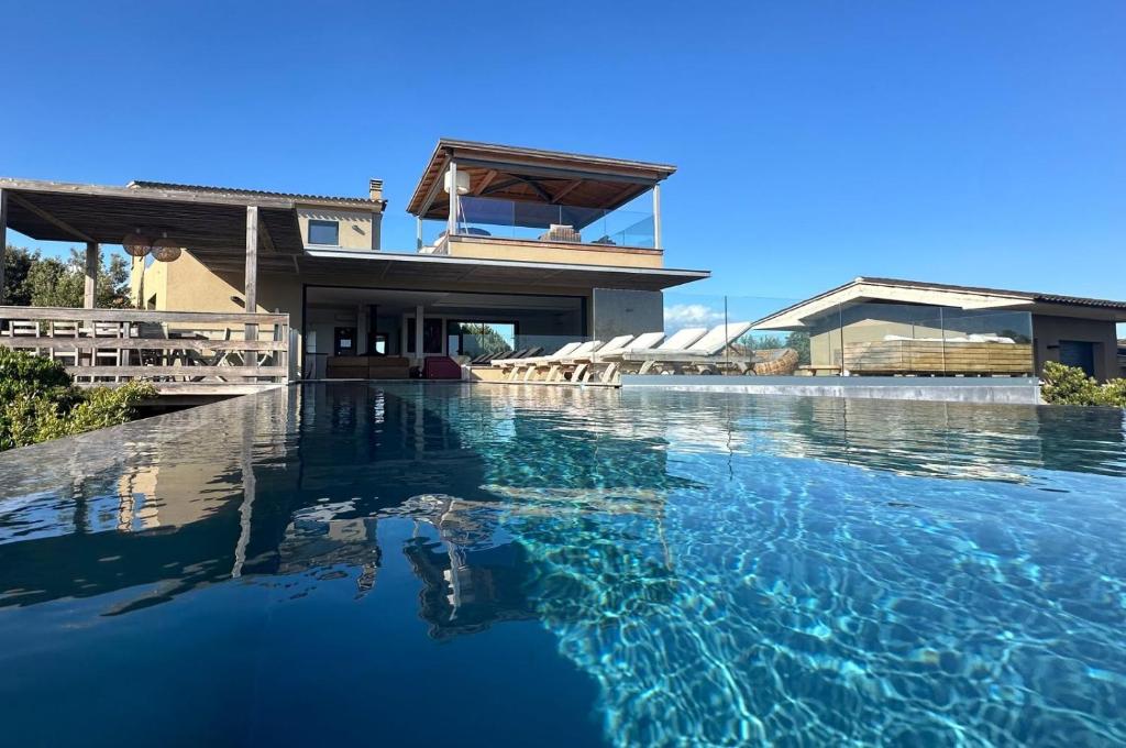 una casa con una piscina di fronte di Villa de luxe surplombant la mer, piscine suspendue a Pianottoli-Caldarello
