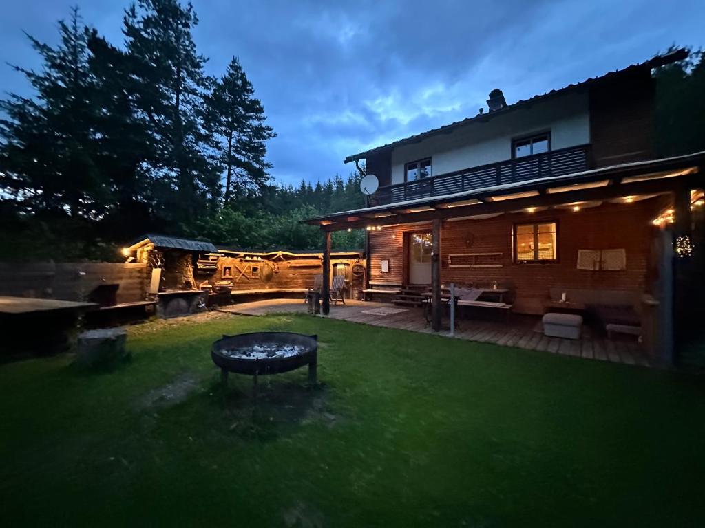 a backyard of a house with a table in the yard at Ferienhaus im Wald in Edelschrott