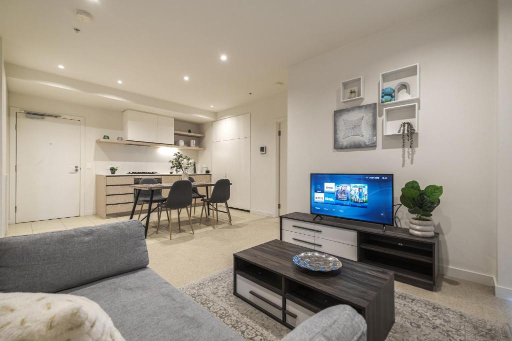 a living room with a couch and a flat screen tv at Brand New 2br2ba Caulfield Parkbalcony Poolgym in Melbourne