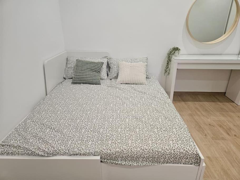 a bed in a white room with a mirror at Casa vacanza Lago di Lesina in Lesina