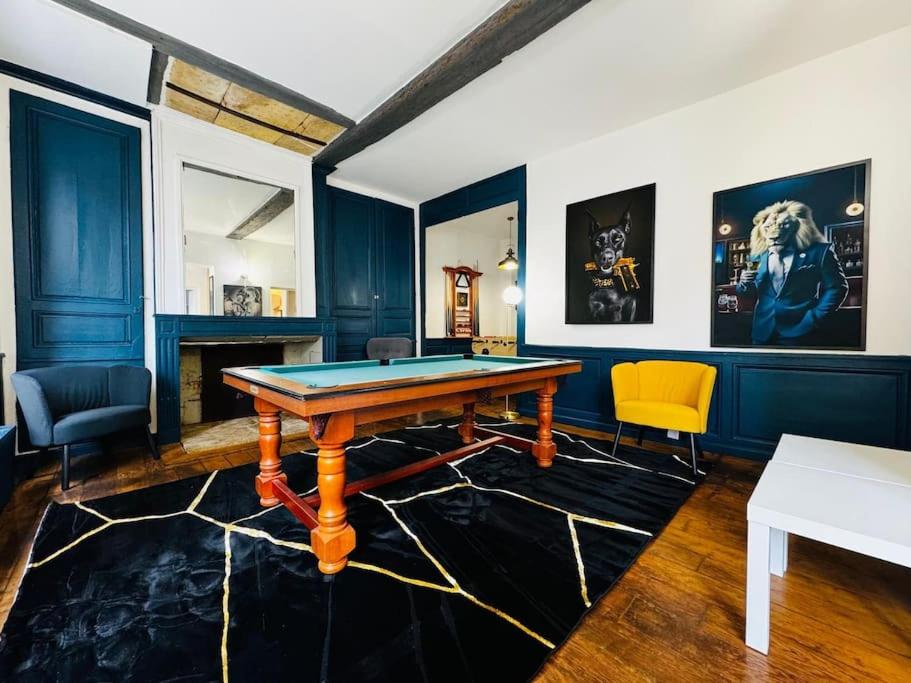 Cette chambre comprend une table de ping-pong et des chaises. dans l'établissement Sainte-barbe T4, Billard à 2 pas du château fort, à Sedan