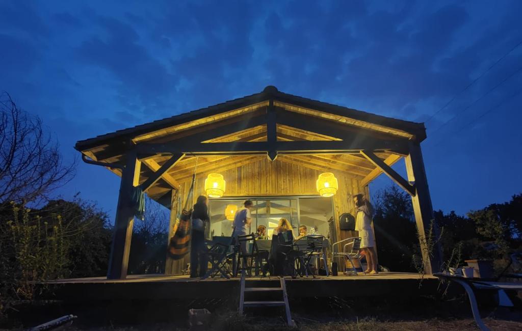 un groupe de personnes dans un pavillon la nuit dans l'établissement Maison bord de mer, à La Tremblade