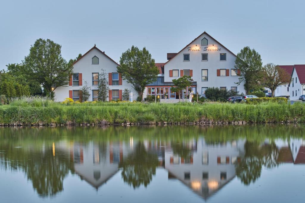 a row of houses next to a body of water at Landhotel Seerose in Langenzenn
