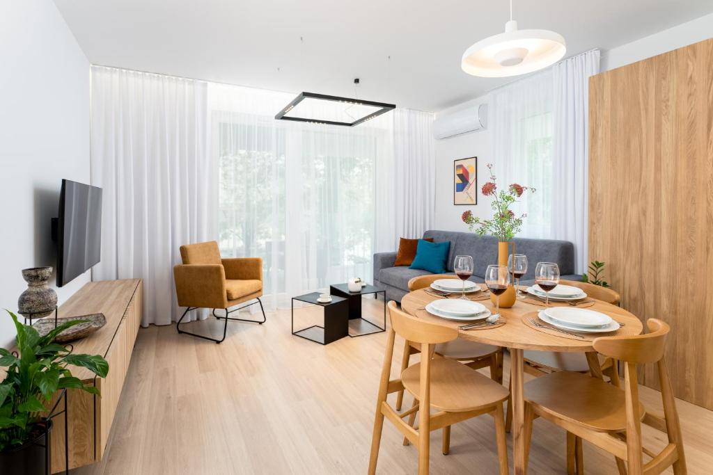 un salon avec une table avec des chaises et un canapé dans l'établissement Stare Miasto z widokiem na ogród, bezpłatny parking, szybkie Wi-Fi, à Cracovie