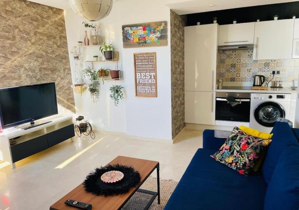 Una sala de estar con un sofá azul y una mesa. en Bel Appartement Cosy dans le centre de Casablanca, en Casablanca