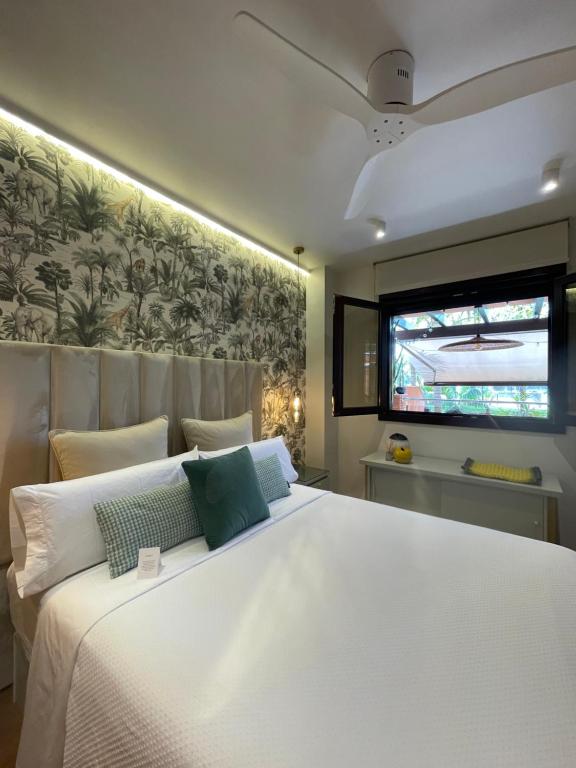 a bedroom with a large white bed and a window at La casa de Mateo Playa Granada in Motril