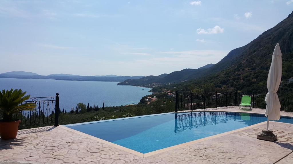 a swimming pool with a view of a lake at Villa Daniella studio with private pool in Nisaki