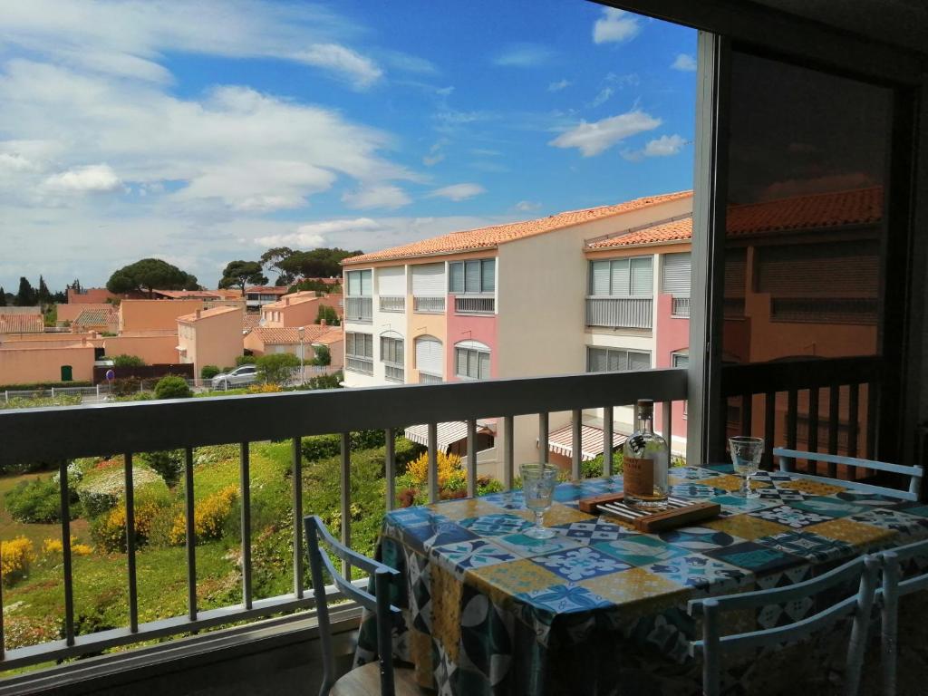 - une table sur un balcon avec vue sur un bâtiment dans l'établissement Bel appartement 4 personnes dans résidence privée avec Parking, au Cap d'Agde