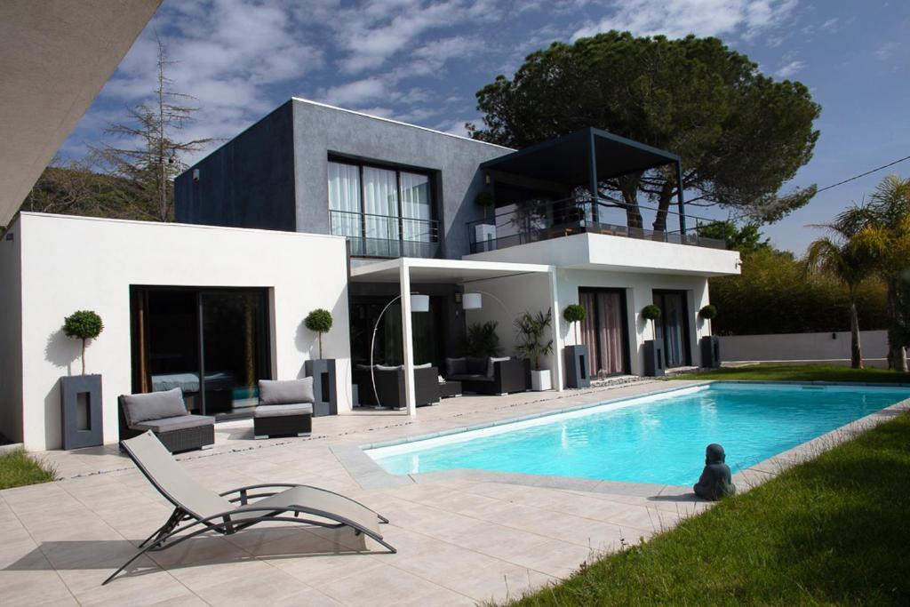 ein Haus mit einem Swimmingpool vor dem Haus in der Unterkunft Villa prestigieuse « Bellezza » By HC in Carqueiranne