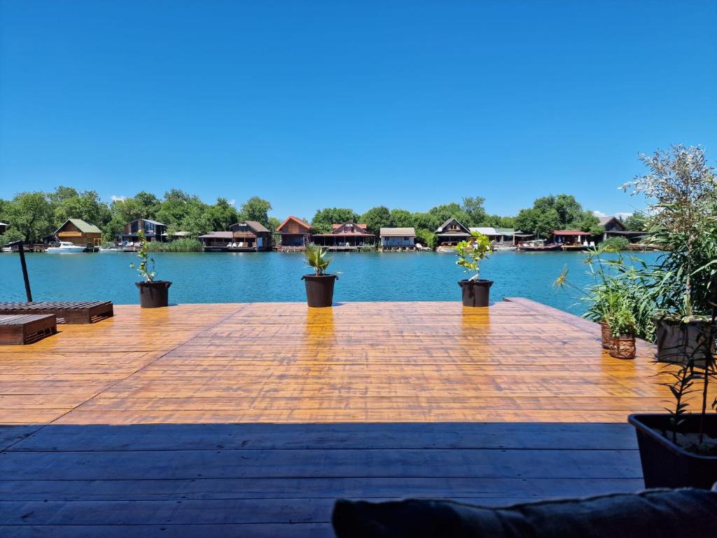 a wooden deck with plants on the water at NuA House "Kapri" in Gornji Štoj