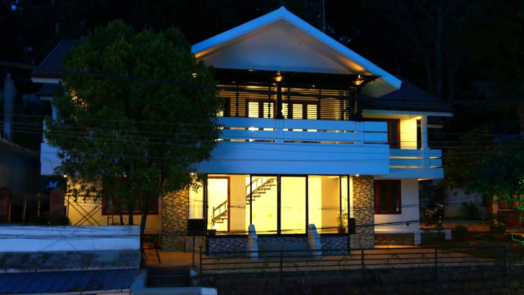 a house with a lit up facade at night at Olive Periyar in Thekkady