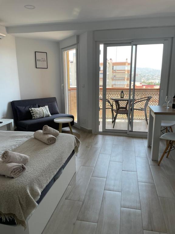 a bedroom with a bed and a couch and a balcony at Estudio Oceanview Torre del Mar in Torre del Mar
