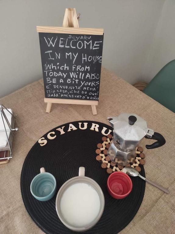 a table with a sign and some bowls on it at Casa Vacanze Scyauru in Santa Elisabetta