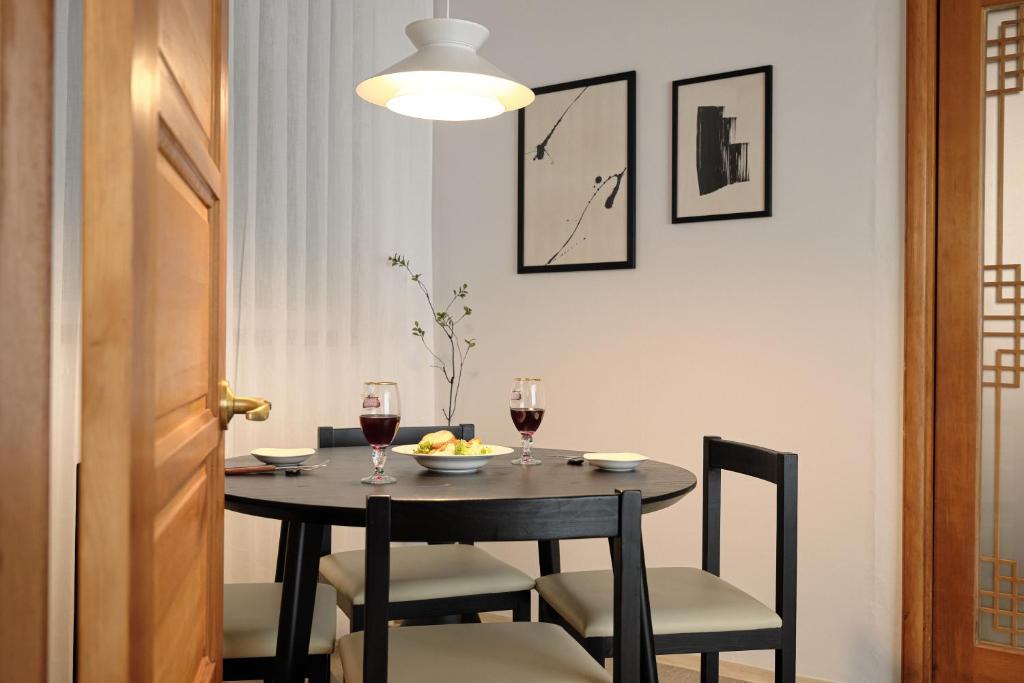 a dining room table with two glasses of wine at Your-jin stay Seoul in Seoul