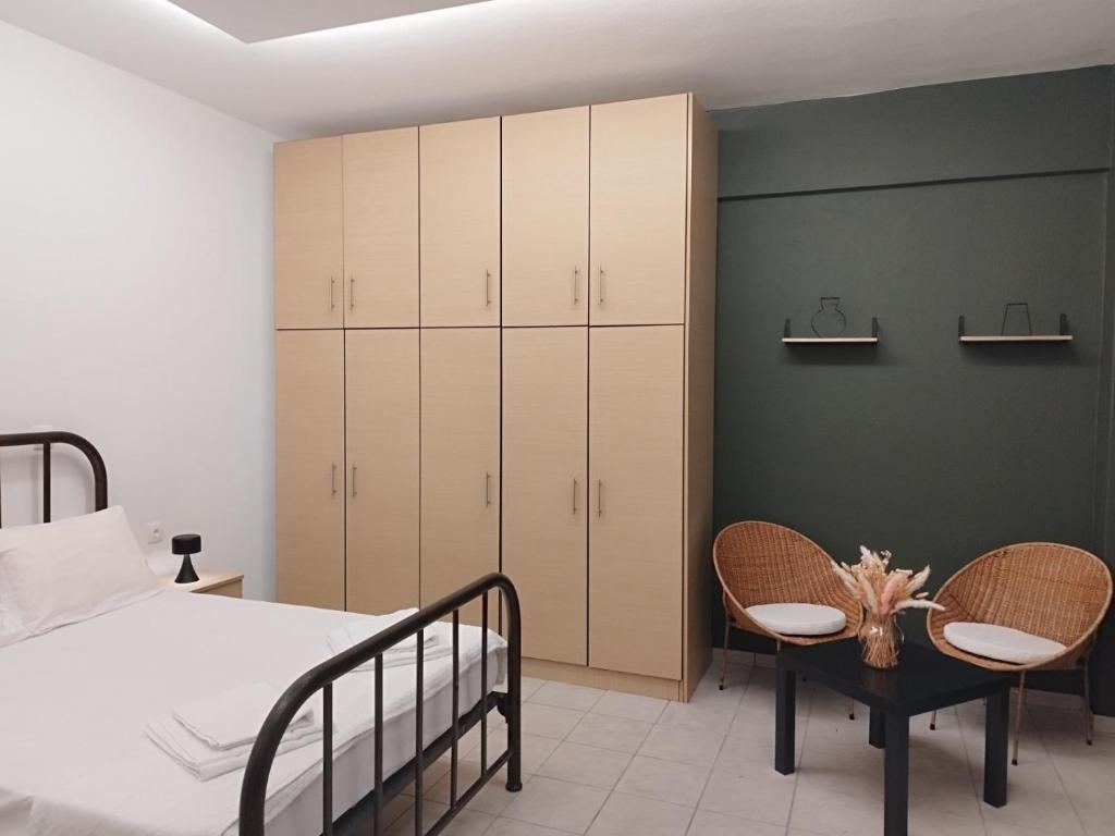 a bedroom with a bed and two chairs at Artan`s garden house in Kalyves Poligirou
