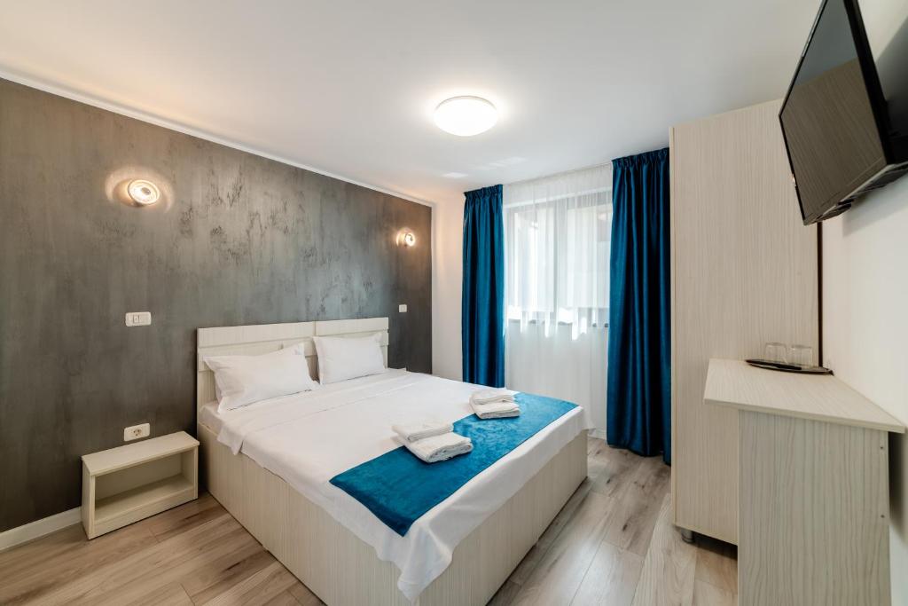 une chambre avec un lit et une télévision à écran plat dans l'établissement Casa Maria EFORIE NORD, à Eforie Nord