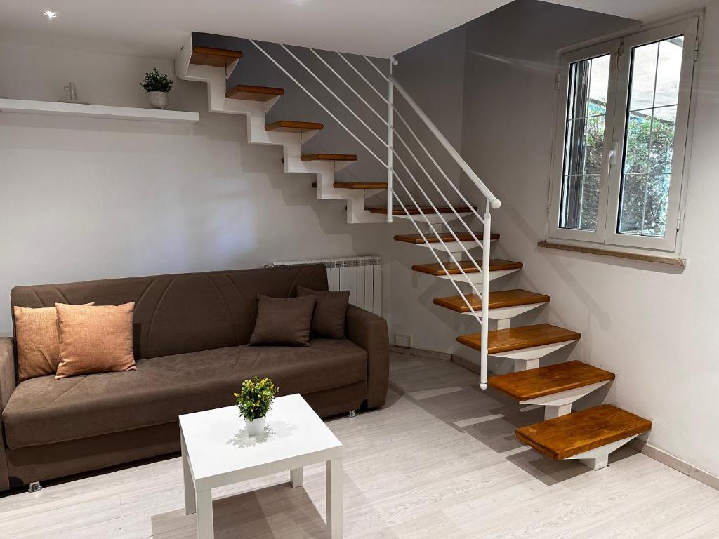 a living room with a couch and a staircase at Casa di Nia Pietralata in Rome