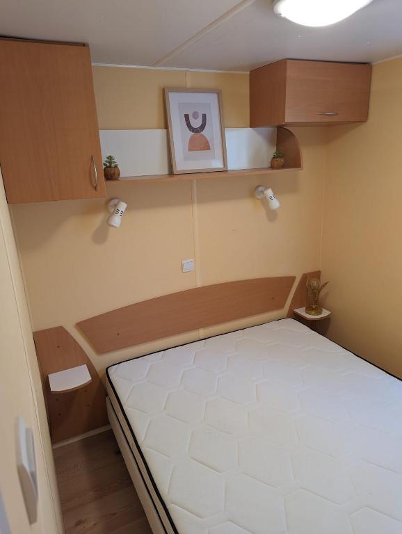 une petite chambre avec un lit dans une pièce dans l'établissement Mobilhome tout confort dans domaine boisé, au Castellet
