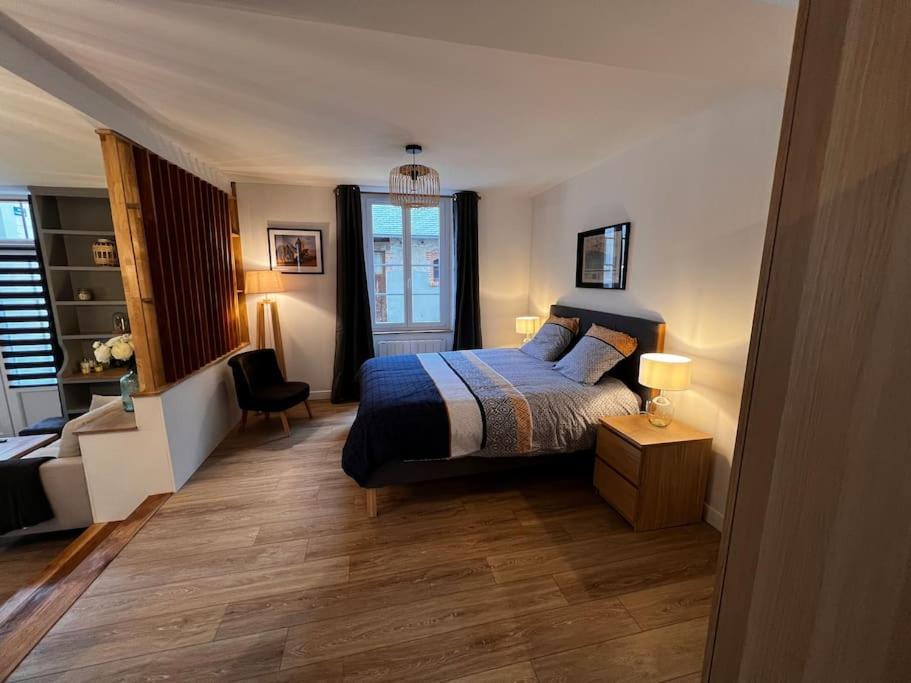 Un dormitorio con una cama y un escritorio y una ventana. en Grand Studio Ceo Bauer, en plein centre de Sainte-Mère-Eglise pour 2 pers, en Sainte-Mère-Église